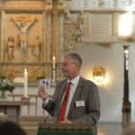 Propst Funck hält seine Begrüßungsrede in einer Kirche