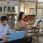 Eine Frau an der Geige und ein Mann am Keyboard spielen gemeinsam eine Musikstück